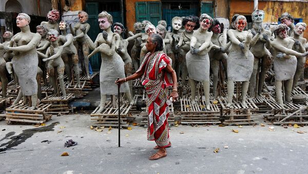 امرأة هندية تقف أمام تمثايل لشخصيات هندية، التي سيتم وضعها حول الإلهة كالي خلال مهرجان كالي-بودجا في كلكتا، الهند 24 أكتوبر/ تشرين الأول 2016 - سبوتنيك عربي