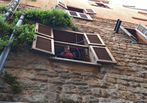طفل صغير يطل من نافذة بيته في ميدنة صيدا - سبوتنيك عربي