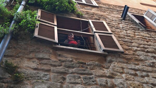 طفل صغير يطل من نافذة بيته في ميدنة صيدا - سبوتنيك عربي