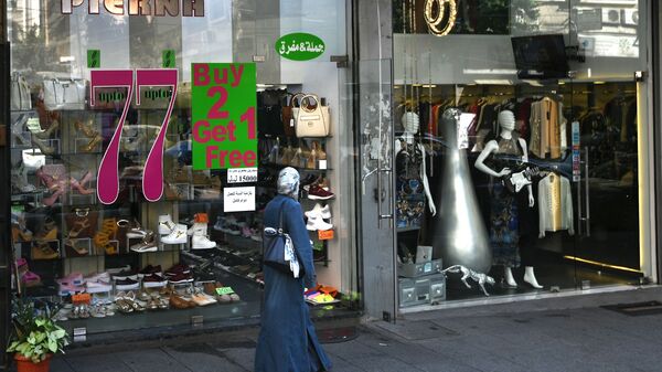 امرأة تسير بجوار محل تجاري في مدينة بيروت - سبوتنيك عربي