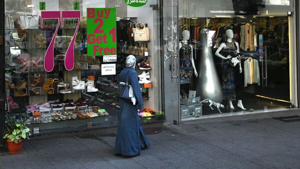 امرأة تسير بجوار محل تجاري في مدينة بيروت - سبوتنيك عربي