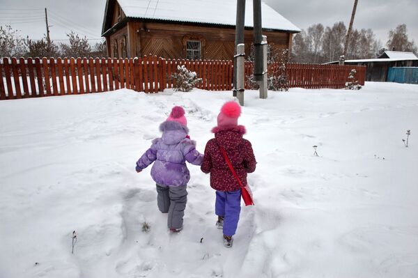 أطفال يلعبون على الثلج الكثيف في قرية بيريزوفكا بمقاطعة تومسك - سبوتنيك عربي