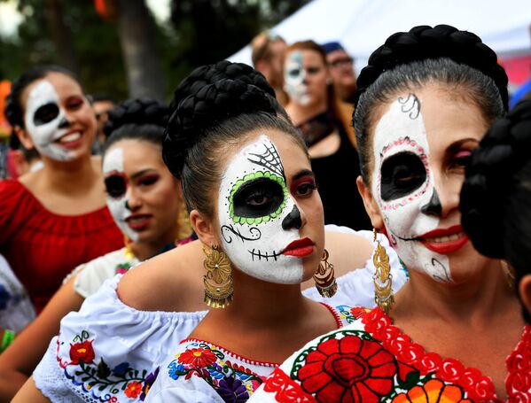 أشخاص يرتدون أزياء مهرجان يوم دي دي لوس مويرتوس (يوم الأموات) بمقبرة هوليوود في هوليوود، وهي فعالية لإحياء التراث المكسيكي في الولايات المتحدة، 29 أكتوبر/ تشرين الأول 2016 - سبوتنيك عربي