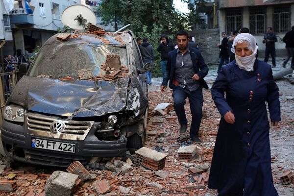 المواطنون يمرون بجوار أثار التفجيرات التي وقعت في ديار بكر، تركيا 4 نوفمبر/ تشرين الثاني 2016 - سبوتنيك عربي