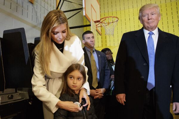 المرشح الجمهوري دونالد ترامب ينظر إلى ابنته إيفانكا وهي تضع شارة I Voted (أنا انتخبت) لابنتها الصغيرة أرابيلا في نيويورك، 8 نوفمبر/ تشرين الثاني 2016 - سبوتنيك عربي
