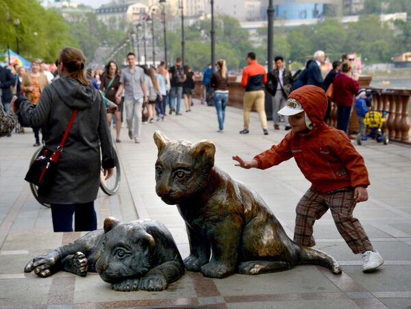 طفل يلعب مع تمثال تيغارياتا (النمور الصغيرة) على ضفة سبورتيفنايا في فلاديفوستوك - سبوتنيك عربي