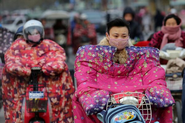 راكبو الدراجات النارية يرتدون أقنعة لحمايتهم من الرياح الباردة في ليانيانغ، الصين 23 نوفمبر/ تشرين الثاني 2016 - سبوتنيك عربي