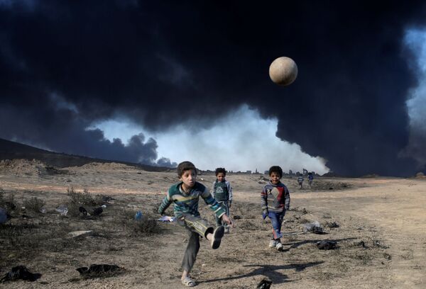 أطفال يلعبون كرة القدم في القيارة جنوبي الموصل، العراق 23 نوفمبر/ تشرين الثاني 2016 - سبوتنيك عربي