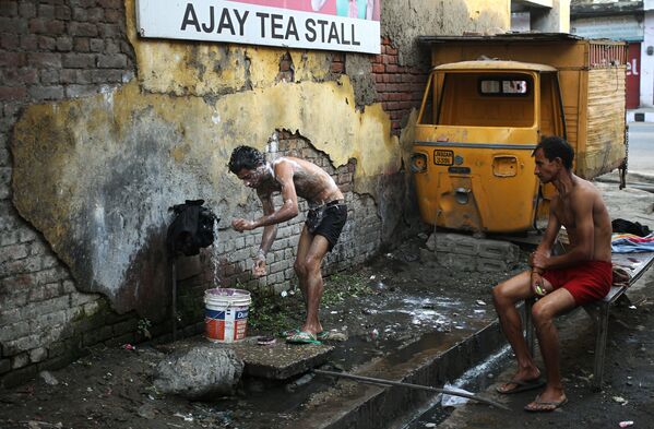 رجل يستحم في  أحد شوارع مدينة جامو، الهند 22 نوفمبر/ تشرين الثاني 2016 - سبوتنيك عربي