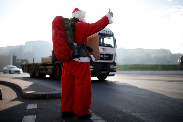 رجل فرنسي (كابتن ريمي) يرتدي زي بابا نويل خلال رحلته في باريس، فرنسا، ديسمبر/ كانون الأول 2016 - سبوتنيك عربي