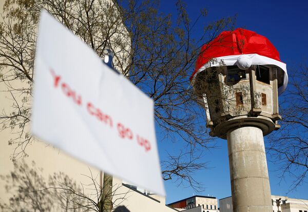 سياح يزورون برج المراقبة السابق في ساحة بوتسدامر بلاتز وعليه غطاء رأس لـ سانتا كلاوز في برلين، ألمانيا، 29 نوفمبر/ تشرين الثاني 2016 - سبوتنيك عربي