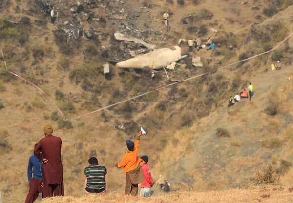 صبي يلعب بالقرب من مكان سقوط الطائرة المنكوبة، باكستان 8 ديسمبر/ كانون الأول 2016 - سبوتنيك عربي