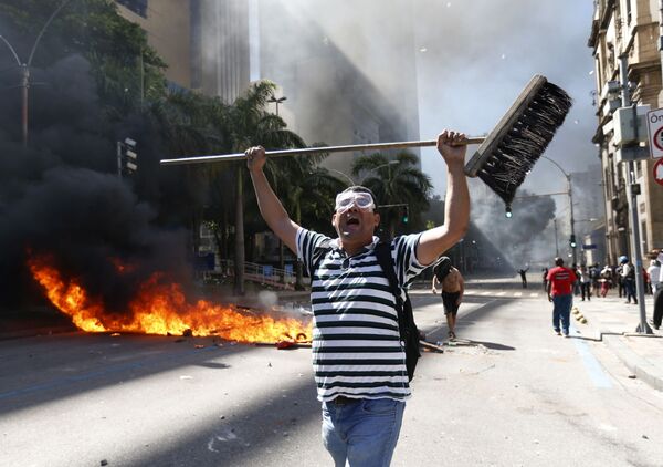 رجل يمسك رجل مكنسة خلال الاحتجاجت ضد تدابير التقشف التي تجري مناقشتها في حكومة ريو دي جانيرو، البرازيل 6 ديسمبر/ كانون الأول 2016 - سبوتنيك عربي