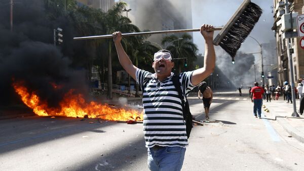 رجل يمسك رجل مكنسة خلال الاحتجاجت ضد تدابير التقشف التي تجري مناقشتها في حكومة ريو دي جانيرو، البرازيل 6 ديسمبر/ كانون الأول 2016 - سبوتنيك عربي
