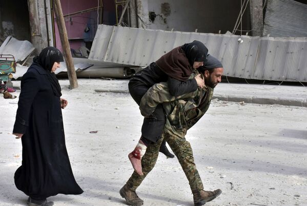 جندي سوري يحمل امرأة على ظهره في حلب الشرقية، 12 ديسمبر/ كانون الأول 2016 - سبوتنيك عربي