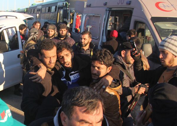 أعضاء الصليب الأحمر والهلال الأحمر في انتظار مغادرة المجموعة الأخيرة من الحافلات الخضراء شرق مدينة حلب، 15 ديسمبر/ كانون الأول 2016 - سبوتنيك عربي