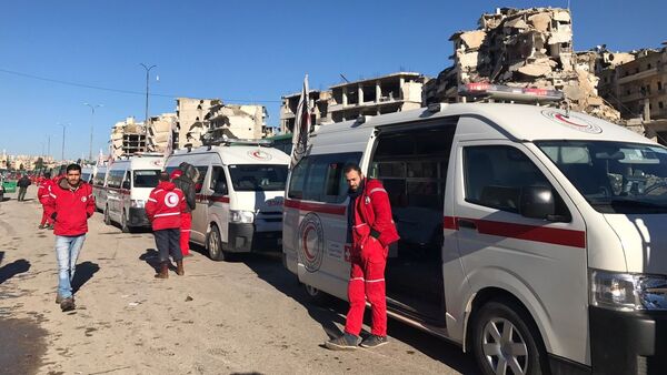 أعضاء الصليب الأحمر والهلال الأحمر في انتظار مغادرة المجموعة الأخيرة من الحافلات الخضراء لمدينة حلب الشرقية، 15 ديسمبر/ كانون الأول 2016 - سبوتنيك عربي