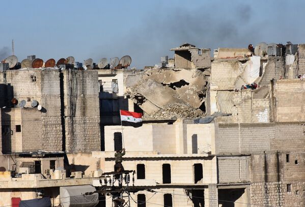 بعد مغادرة المسلحين وأفراد أسرهم منها والعلم السوري يرفرف على سطح أحد المباني في حلب، 15 ديسمبر/ كانون الأول 2016 - سبوتنيك عربي