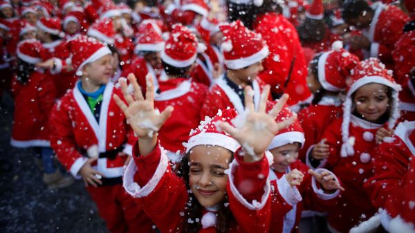 أطفال يرتدون زي سانتا كلاوز (بابا نويل) للمشاركة في إحدى أكبر المسيرات الخيرية وذلك لجمع الطعام للمحتاجين في لشبونة، البرتغال 12 ديسمبر/ كانون الأول 2016 - سبوتنيك عربي