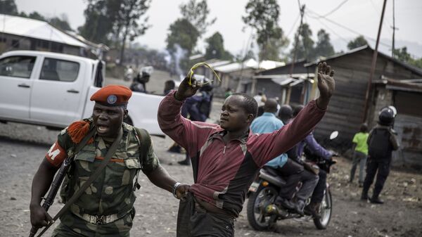 ضابط يلقي القبض على رجل حاول إغلاق الطريق بالحجارة، في حي ماجينغو في غوما، شرق جمهورية الكونغو الديمقراطية، في 19 ديسمبر/ كانون الأول عام 2016، - سبوتنيك عربي