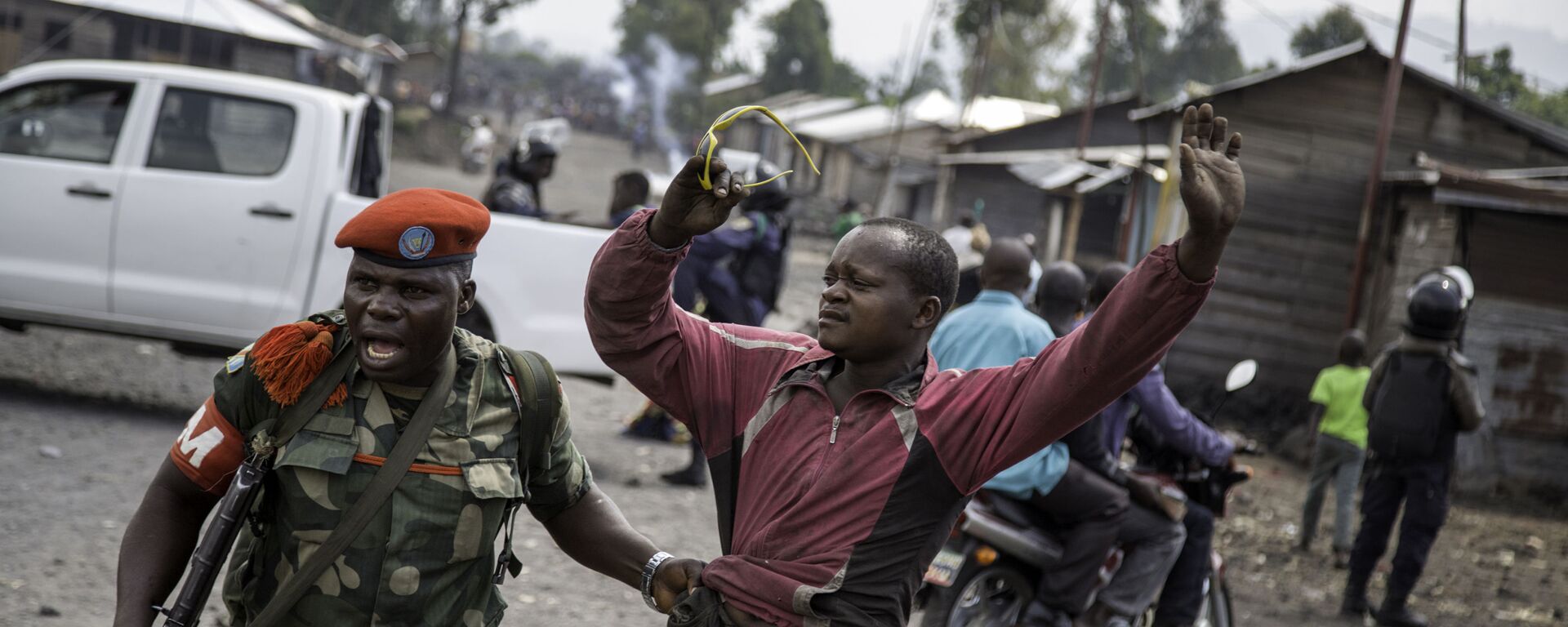 ضابط يلقي القبض على رجل حاول إغلاق الطريق بالحجارة، في حي ماجينغو في غوما، شرق جمهورية الكونغو الديمقراطية، في 19 ديسمبر/ كانون الأول عام 2016، - سبوتنيك عربي, 1920, 22.05.2022