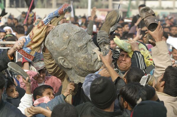 المسلمون الشيعة يضربون مجسماً للرئيس العراقي صدام حسين في إحدى ضواحي مدينة بغداد، 26 ديسمبر/ كانون الأول 2003 - سبوتنيك عربي
