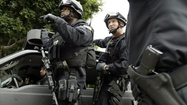 FBI agents in riot gear get information from a Los Angeles Police Department police officer (R) as they head towards the Mexican consulate in Los Angeles - سبوتنيك عربي