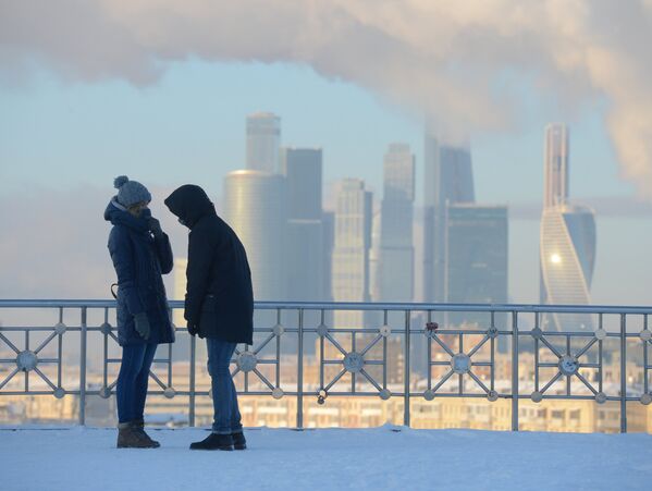 شخصان يقفان على خلفية ناطحات سحاب لـ موسكو سيتي، ودرجة الحرارة 27 تحت الصفر. - سبوتنيك عربي