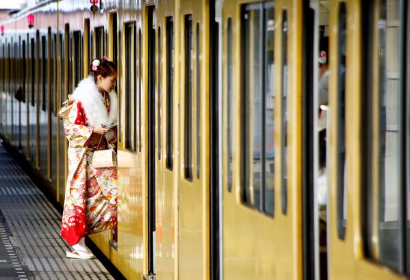 فتاة يابانية تدخل قطار ميترو بطوكيو، اليابان، 9  يناير/ كانون الثاني 2017 - سبوتنيك عربي