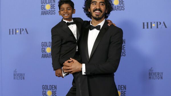 Actor Dev Patel holds actor Sunny Pawar, who portrays the same character as Patel in the movie Lion - سبوتنيك عربي