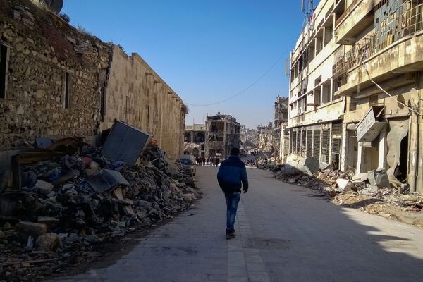 رجل يسير في شارع بحي الناظرية في حلب، سوريا - سبوتنيك عربي