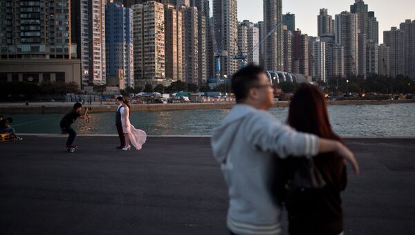 A couple (L) pose for their pre-wedding photographs on a public pier in Hong Kong on November 28, 2015 - سبوتنيك عربي