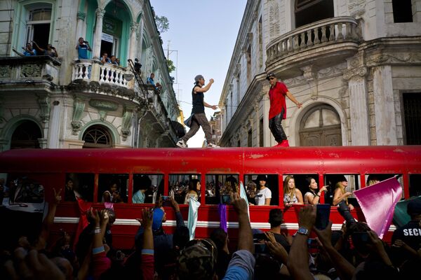 المغني الشهير إنريكيه إغليسياس والمغني الكوبي ديسمبر بوينو يرقصان على سطح حافلة خلال تصوير فيديو كليب خاص بهما في هافانا، كوبا 11 يناير/ كانون الثاني 2017 - سبوتنيك عربي