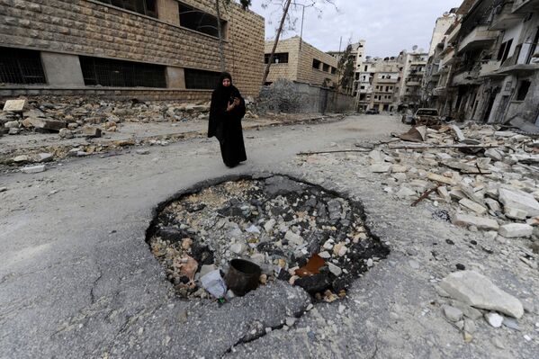 امرأة تلتقط صورة لدمار في حلب، سوريا 30 يناير/ كانون الثاني 2017 - سبوتنيك عربي