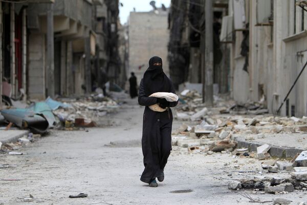 امرأة تحمل خبزاً في أحد شوارع حلب، سوريا 30 يناير/ كانون الثاني 2017 - سبوتنيك عربي