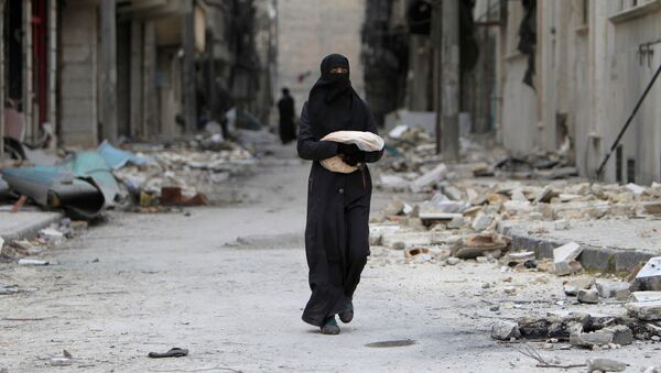 امرأة تحمل خبزاً في أحد شوارع حلب، سوريا 30 يناير/ كانون الثاني 2017 - سبوتنيك عربي