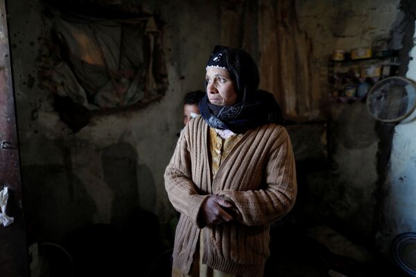 كلثوم (40 عاماً) تقف في منزلها بقرية أفلو بجبال الأطلس الصحراوي، الجزائر 26  يناير/ كانون الثاني 2017 - سبوتنيك عربي