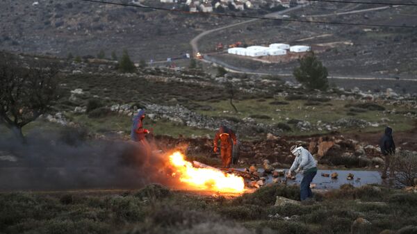 مستوطنون إسرائيليون يحرقون إطارات السيارات رفضاً على تركهم أمونا شمال شرق رام الله بالضفة الغربية، فلسطين 1 فبراير/ شباط 2017 - سبوتنيك عربي