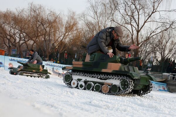 الصينيون يركبون دبابات (لعبة كهربائية) في حديقة تاورانتيغ في اليوم الأخير من أعياد السنة القمرية الصينية الجديدة في بكين، الصين، 2 فبراير/ شباط 2017. - سبوتنيك عربي