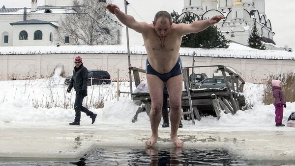 رجل يقفز إلى مياه جليدية بمناسبة عيد الغطاس في محافظة سمولينسك - سبوتنيك عربي
