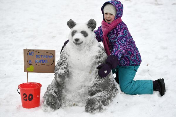 فتاة تلتقط صورة تذكارية مع تمثال من الثلج للدب الباندا في موسكو - سبوتنيك عربي
