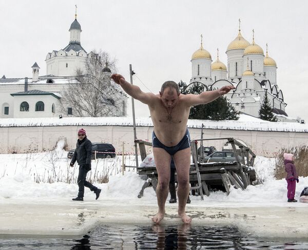 رجل يقفز إلى  المياه الجليدية في عيد الغطاس في محافظة سمولينسك - سبوتنيك عربي