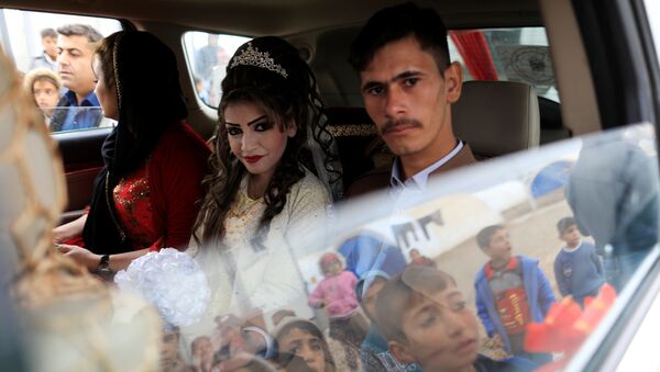 المتزوجان حديثاً، حسين زينو زعنون (26 عاما) وشهد (16 عاما) يجلسان داخل سيارة الفرح في مخيم خازر للنازحين، العراق، 16 فبراير/ شباط 2017 - سبوتنيك عربي