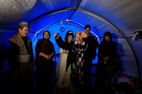 المتزوجان حديثاً، حسين زينو زعنون (26 عاما) وشهد (16 عاما) خلال مراسم الاحتفال بالزواج في مخيم خازر للنازحين من الموصل، العراق 16 فبراير/ شباط 2017 - سبوتنيك عربي