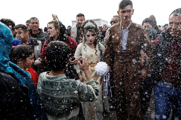 المتزوجان حديثاً، حسين زينو زعنون (26 عاما) وشهد (16 عاما) خلال مراسم الاحتفال بالزواج في مخيم خازر للنازحين من الموصل، العراق 16 فبراير/ شباط 2017 - سبوتنيك عربي