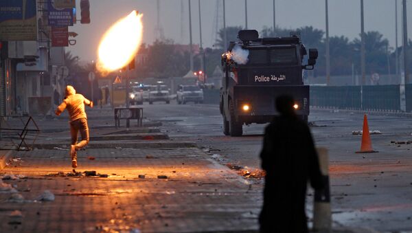 الذكرى السادسة لمظاهرات 14 فبراير. شاب يقذف كوكتيل مولوتوف باتجاه سيارة شرطة خلال الاحتجاجات في جنوب المنامة، البحرين 14 فبراير/ شباط 2017 - سبوتنيك عربي