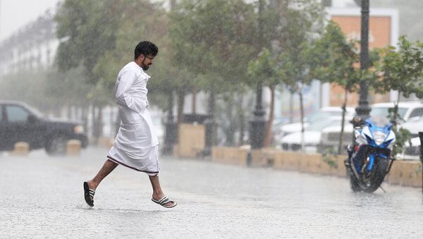 سعودي يجري بسبب الأمطار في العاصمة السعودية الرياض - سبوتنيك عربي