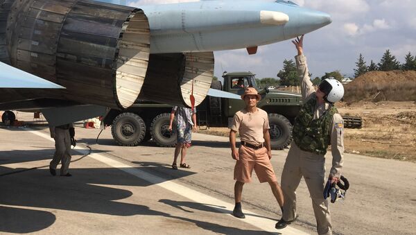 مجموعة من الطيارين الروس يسجهزون القاذفة سو-30 قبيل الإقلاع من قاعدة المطار العسكري السوري حميميم بسوريا - سبوتنيك عربي