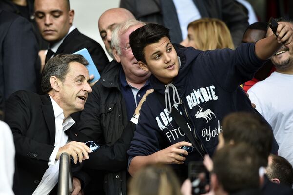 رئيس فرنسا السابق نيقولا ساركوزي يلتقط صورة سيلفي مع صبي خلال مباراة كرة قدم - سبوتنيك عربي