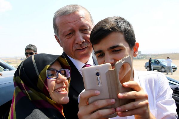 رئيس تركيا رجب طيب إردوغان يلتقط صورة سيلفي مع المواطنين في أنقرة - سبوتنيك عربي